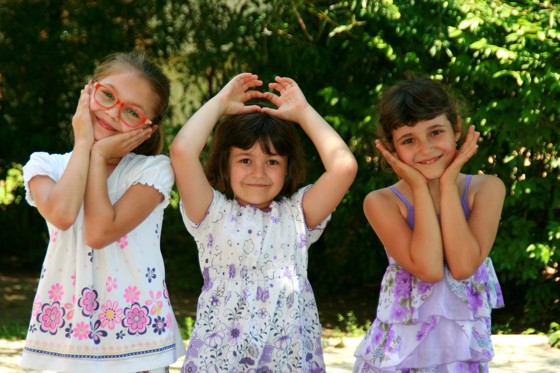 Three smiling students posing playfully outdoors