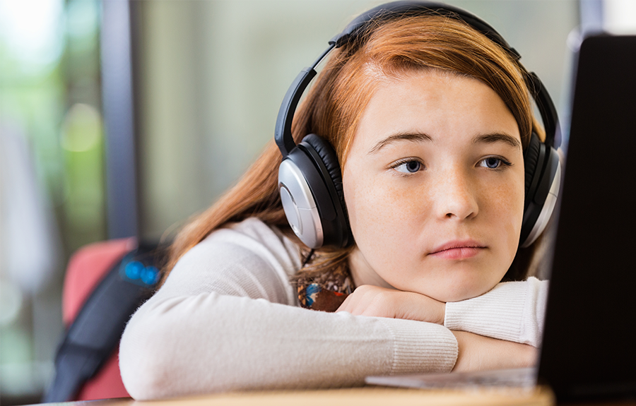 Student with headphones engaged in online learning session