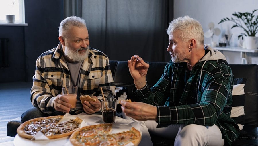 older twin men talking over food