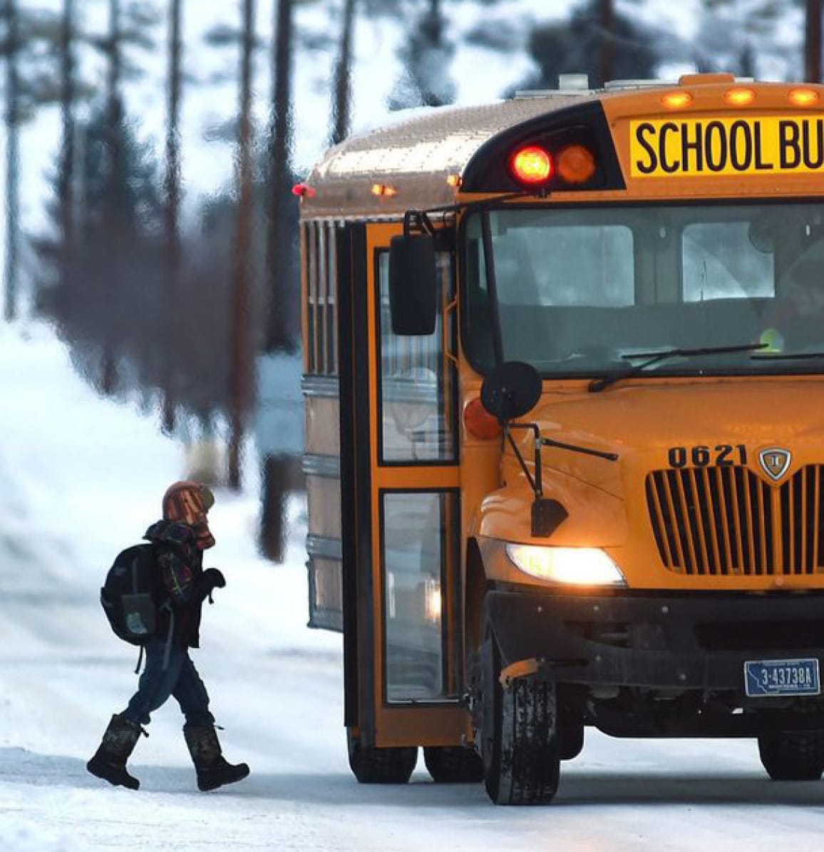 child walking to school bus in the snow