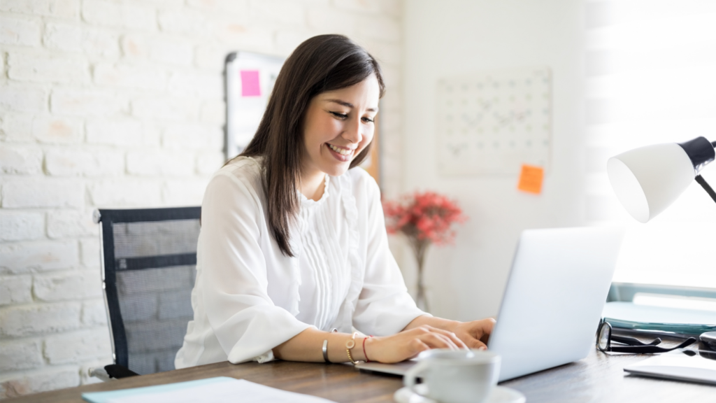 Teletherapist engaging with online therapy tools on laptop in modern office setting