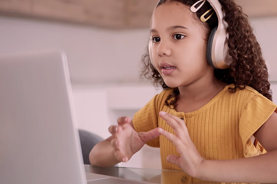 Student engaging in teletherapy session with headphones