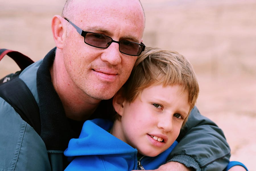 Father and son embracing outdoors, showcasing connection and support