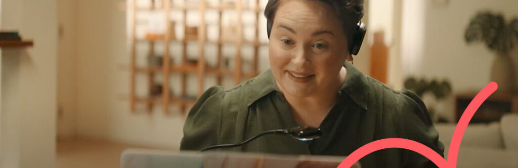Smiling teletherapist engaging in online therapy session via a desktop