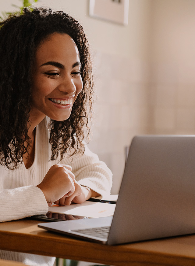 Smiling teletherapist engaging in online therapy session using a laptop