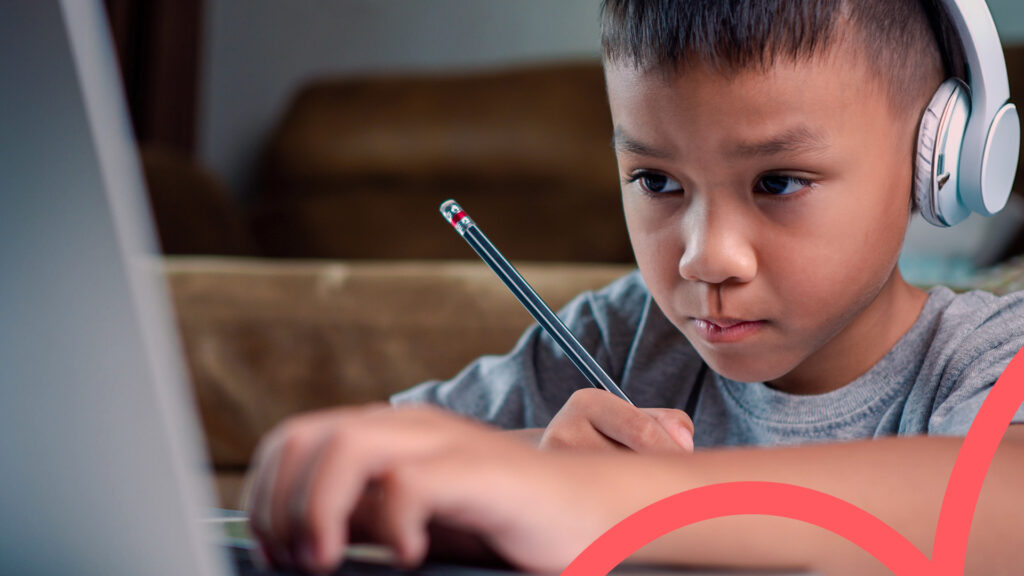 Student focused on online learning with headphones and pencil