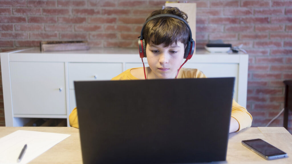 A student engaged with online learning in a classroom setting